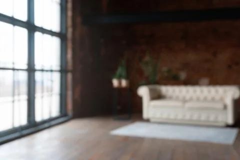 Side defocused view on an open space loft interior with big windows filled wi Stock-Fotos