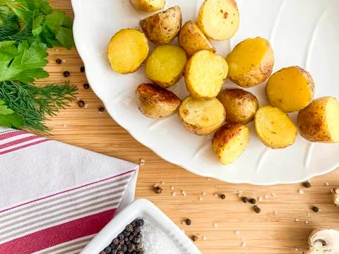Side dishes, second courses, baked potatoes cooked in a rustic way, in a whit Stock Photos