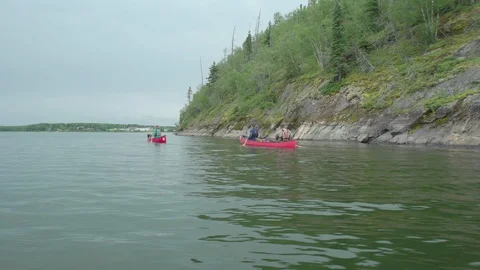 Side dolly on two canoes paddling away Stock Footage 88344035