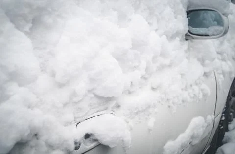 The side door of the car under a layer of fresh snow. Sticky snow on the windows Stock Photos