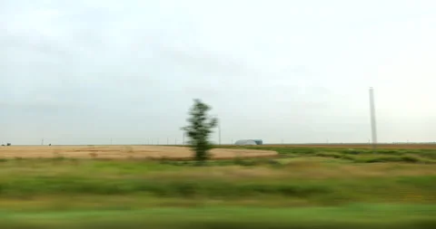 Side driving plate highway through plains and mid America farm land Stock Footage 287489416
