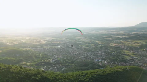 Side drone pass left to right of paraglider over Sokobanja with Rtanj Mountain Stock Footage 328537500