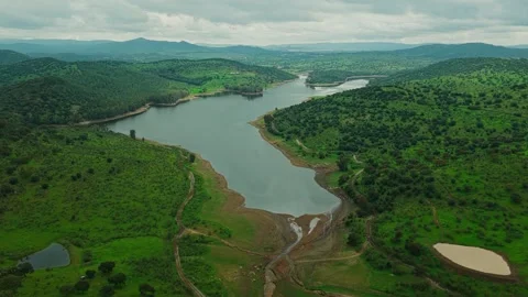 Side drone shot of big lake in middle of hills in cloudy portugal Video stock 333305871