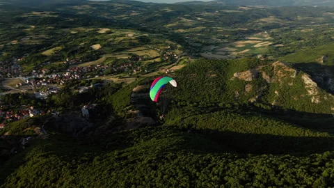 Side drone shot left to right of paraglider over Ozren Mountain valley, Serbia Stock Footage 328634816