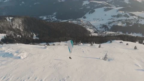 Side Drone Shot Of Tandem Paraglide Landing On Snow Covered Mountains 스톡 동영상 149201423