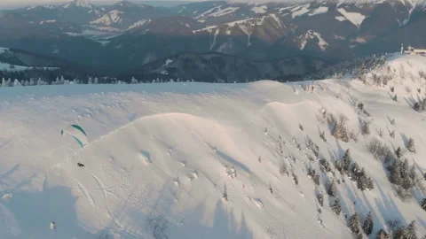 Side Drone Shot Of Tandem Paraglide Over Snow Covered Mountains During Vídeo Stock 149201461