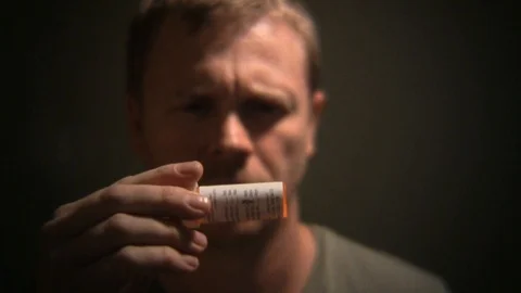 Side effects titles over man looking at pill bottle ingredients. Stock Footage 99607462