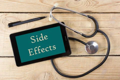 Side Effects- Workplace of a doctor. Tablet, medical stethoscope, black pen on Stock Photos