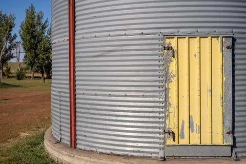Side entry door hatch on a flat bottomed metal grain bin on a family farm. Foto stock
