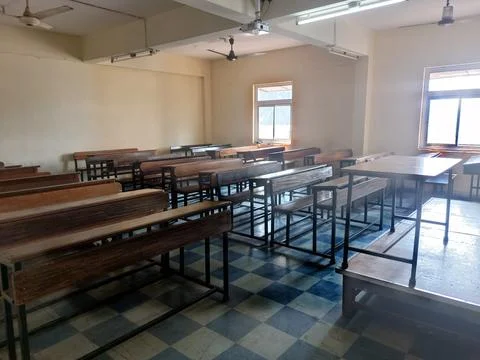 Side entry-view of college classroom with brown benches chairs, furniture Stock Photos