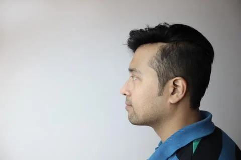 Side face of an asian man without expression looking towards a copy space with Stock Photos