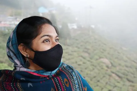 A side facing portrait of a mid 30s indian looking up jovially in winter wear Stock Photos