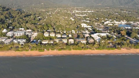 A side flight along a beach with luxury hotels and resorts at Sunrise, 4K 動画素材 106769432