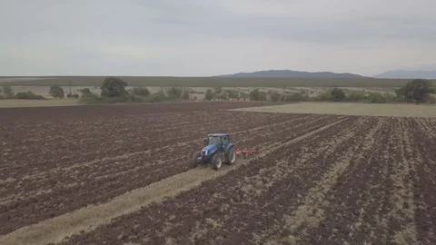 Side follow shot on a Farmer in tractor preparing land with seedbed cultivator Stock Footage 116048784