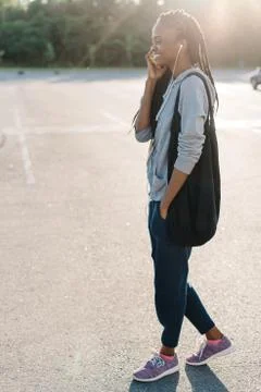 Side full-length view of the joyful afro-american teenager having conversation Stock Photos