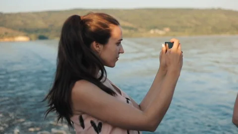 A side half-body view of a beautiful girl with a ponytail taking a picture with Stock-Footage 96190458