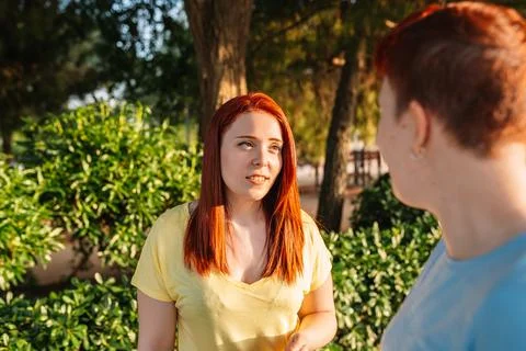 Side image of a cute and charming young woman having a lively conversation with Stock Photos
