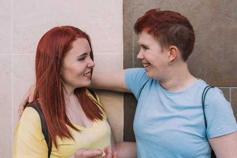 Side image of two young friends, happy and smiling while looking at each other Stock Photos
