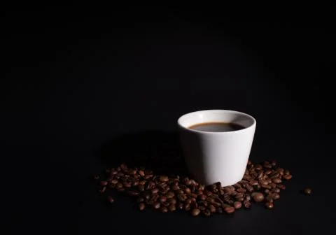 Side light on a white cup set in coffee grains Stock Photos