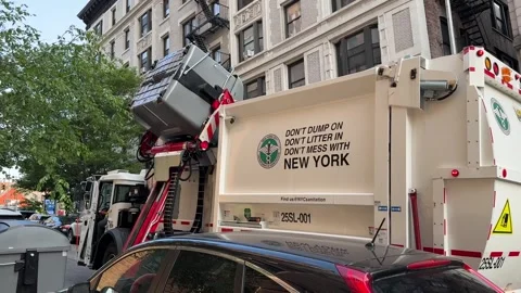 Side-loading garbage truck collecting trash from large bins in New York City Stock Footage 310614471