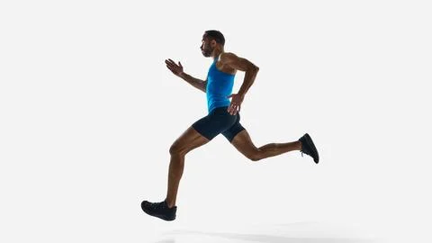 Side low angle view of muscular man, runner in motion, sprinting, training Stock Photos