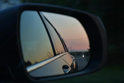 Side mirror car reflection of driving car in dusk Foto stock