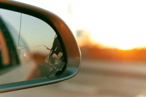 Side mirror of the car with a view back. Broken mirror close up. Stock Photos