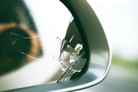 Side mirror of the car with a view back. Broken mirror close up. Stock Photos