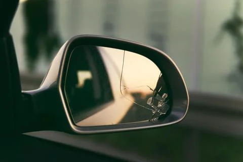 Side mirror of the car with a view back. Broken mirror close up. Stock Photos