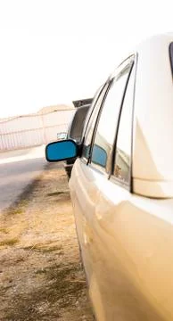 Side mirror of a gray car side view, sun reflection Stock Photos