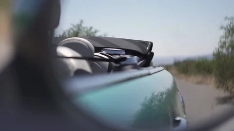 Side mirror perspective of a green car on a sunny day on the road in slow motion Video stock 130408038