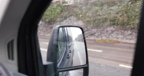Side mirror view car video out of van not in motion, stopped at red light Stock Footage 230487401
