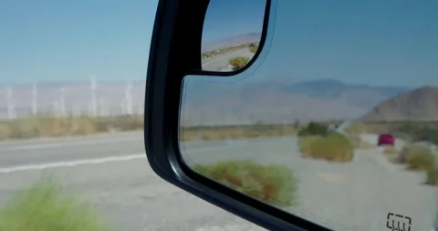 Side Mirror View of Desert Road with Wind Turbines 스톡 동영상 323346393