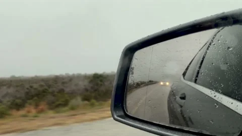 Side mirror view driving on a grey rainy day Stock Footage 181465531