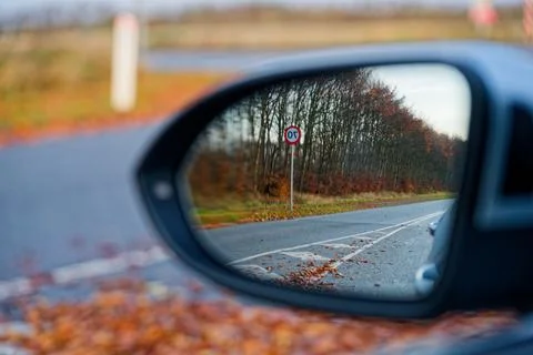 Side mirror view of road and large seventy 70 speed sign Stock Photos