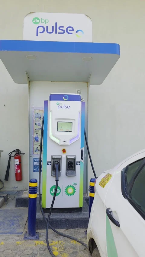 Side movement shot car charging at public DC fast charger from Jio BP Pulse with Stock Footage 333009488