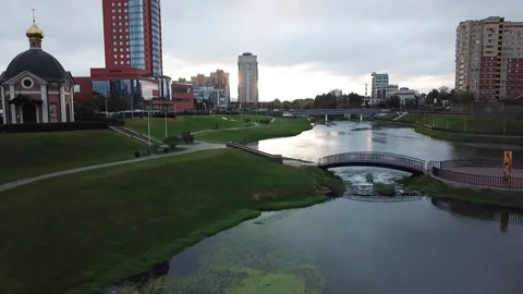 Side moving drone descends over river park and bridge Stock Footage 324635032