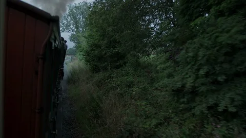 Side of moving vintage steam train carriage with smoke coming from the train Stock Footage 128420094