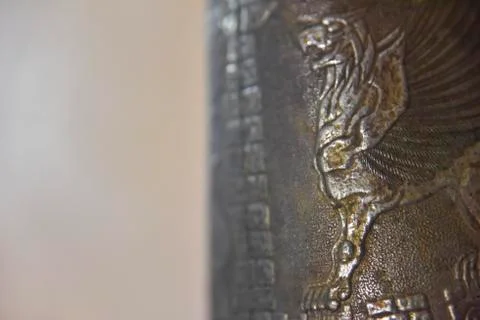 Side of an old cooper bottle with a griffon image on it Stock Photos