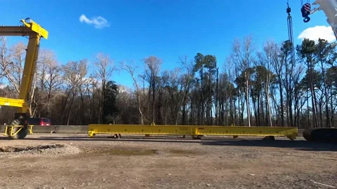 Side pan massive yellow road construction machine where a new bridge is being Stock Footage 152170986