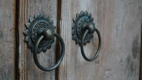 Side Perspective View of Antique Brass Door Knockers on Old Wooden Door Stock Photos