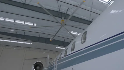 Side of a Plane as a Fan Spins in a Hangar Video stock 208753799