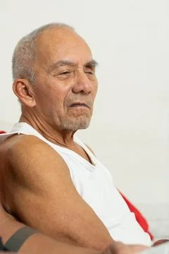Side portrait of elderly man sitting quietly showing aging and thoughtful e.. Stockfoto's