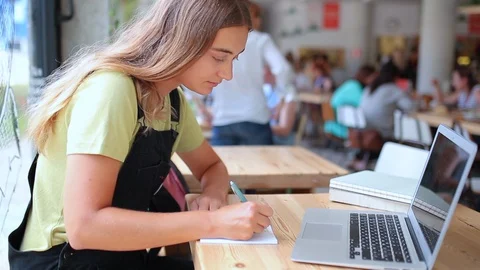 Side portrait female writes in notebook 動画素材 127695374