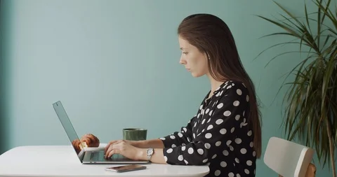 Side portrait of girl working at notebook inside cafe natural daylight  Stock Footage 113730317