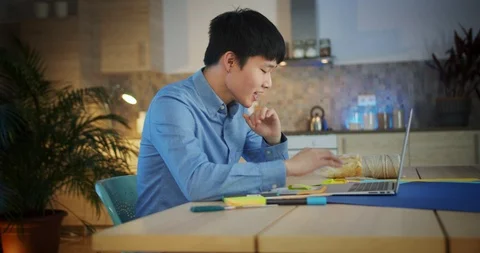 Side portrait of young happy guy in blue shirt enjoying successful homework Stock Footage 124326298
