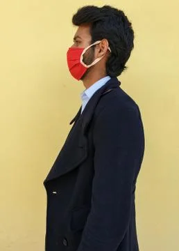 Side pose of a young guy wearing coronavirus mask to protect from the corona Stock Photos