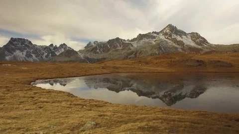 Side POV walking on fall valley lake and snowy mounts approaching sunset.Sunny 動画素材 80097905