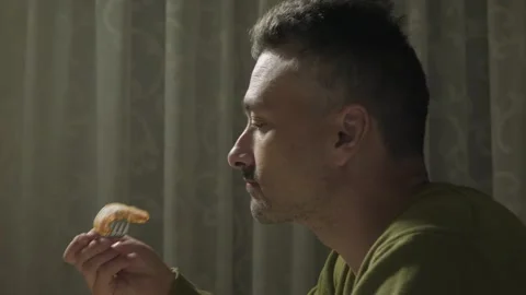 Side profile of adult man eats food Stock Footage 341832940