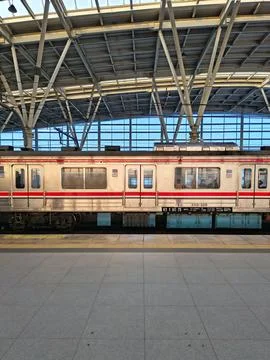 Side profile of an electric commuter train stopped at a modern station Stock Photos